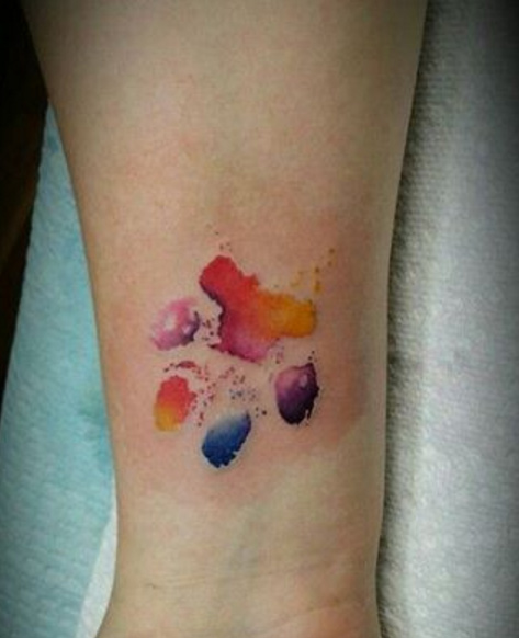 Colorful watercolor paw print tattoo by Milad