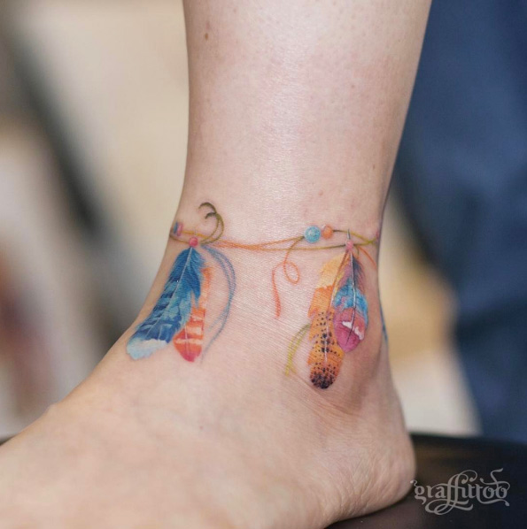 Colorful feathered anklet tattoo by Tattooist River