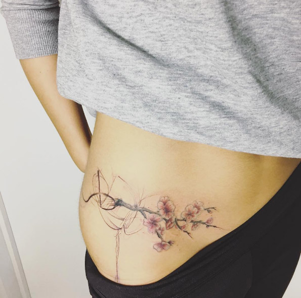 Abstract cherry blossom tattoo on hip by Fatih Odabas