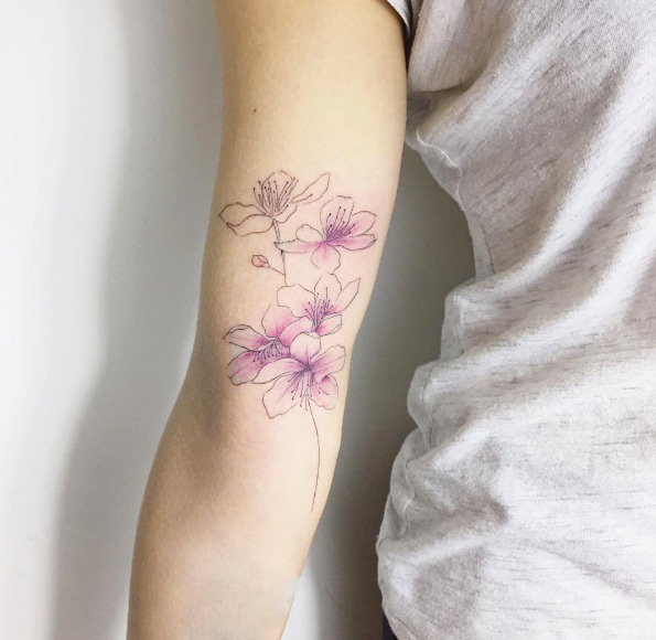 Dainty cherry blossom tattoo by Fatih Odabas