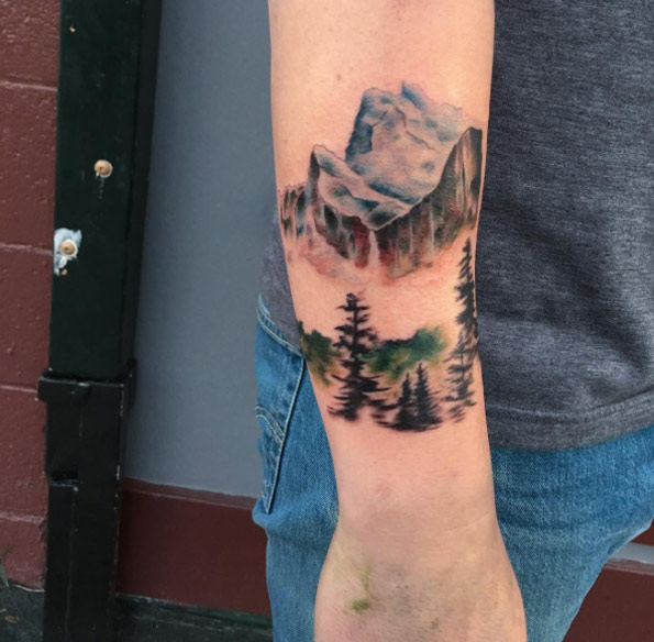 Watercolor mountain range tattoo on forearm by Rachel Ulm