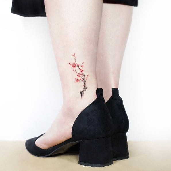 Cherry blossom tattoo on ankle by Jeejae Jung.