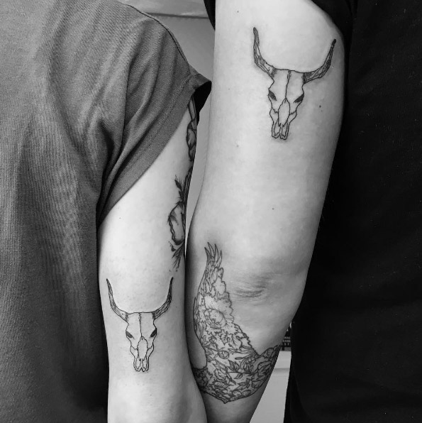 Matching steer skull tattoos by Amber
