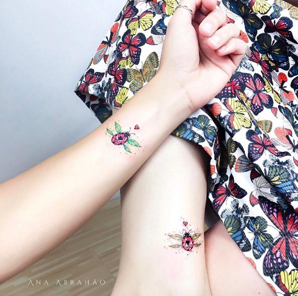 Matching ladybug tattoos by Ana Abrahao
